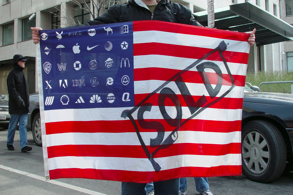 Protester holding Adbusters Corporate American Flag at Bush's 2nd inauguration, Washington DC.