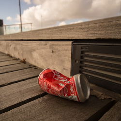Crushed soda can on a boardwalk