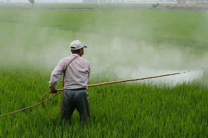 Farmer spraying pesticides on a farm field