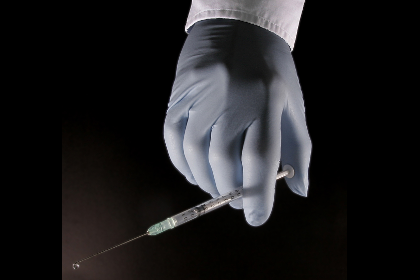 Gloved hand with a syringe