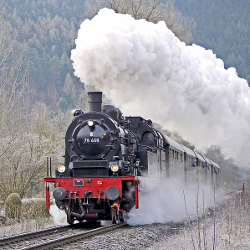 Steam engine barreling down the train tracks