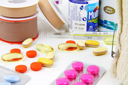 Pills and pharmaceutical capsules with bandages and a thermometer