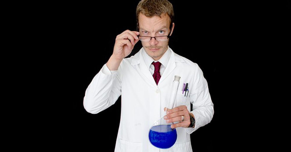 Scientist testing a beaker of blue liquid