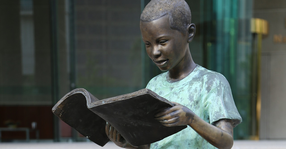 Statue of a child reading a book
