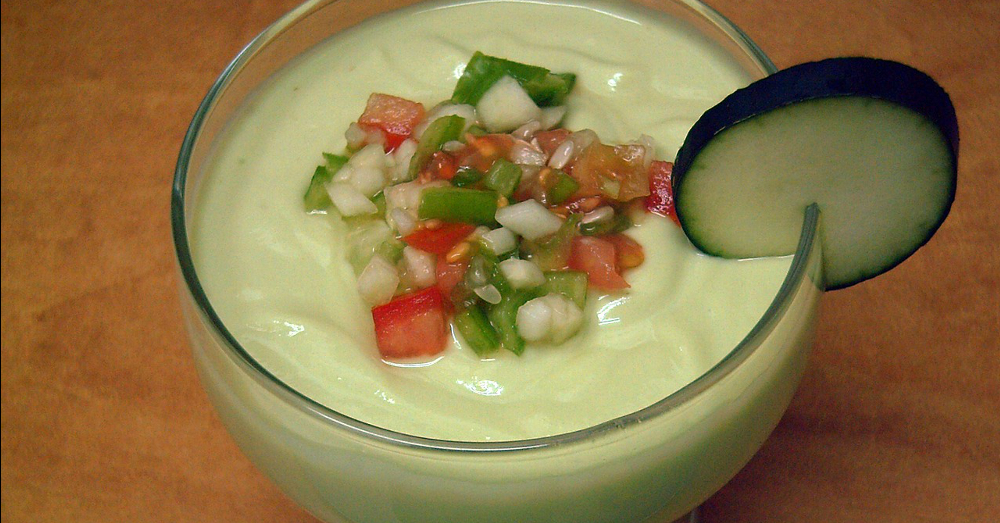 Bowl of cold avocado gazpacho soup with a cucumber garnish