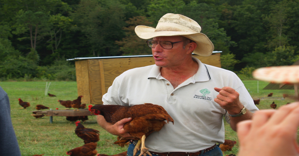Joel Salatin speaking while holding a chicken