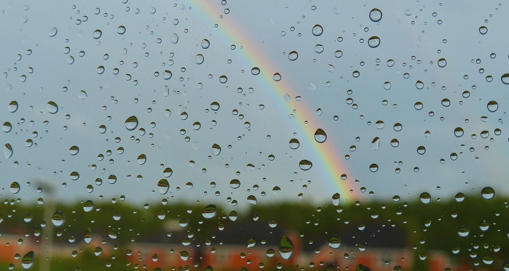 Rainbow through windows covered in rain