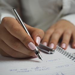 Woman writing in a notebook with a fountain pen