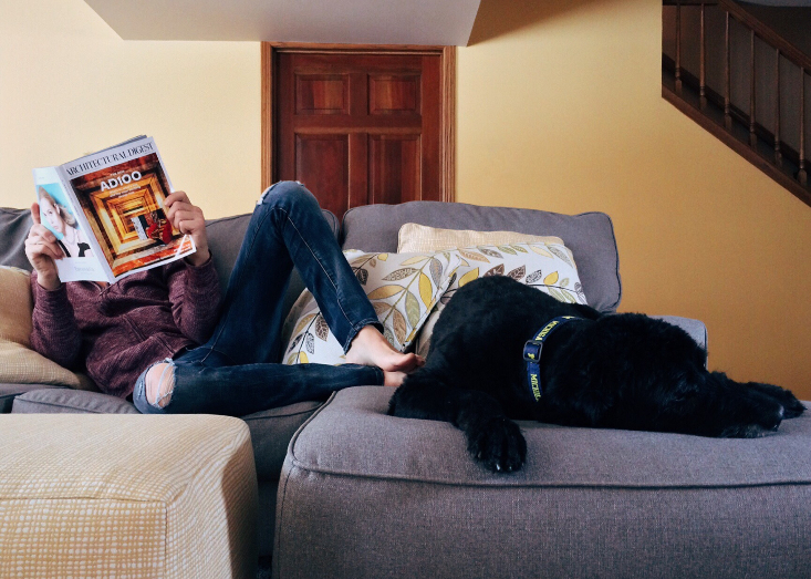 Relaxing at home with the dog and reading a magazine