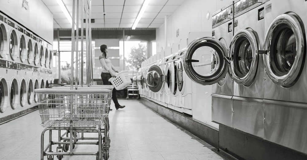Someone doing laundry at a laundromat