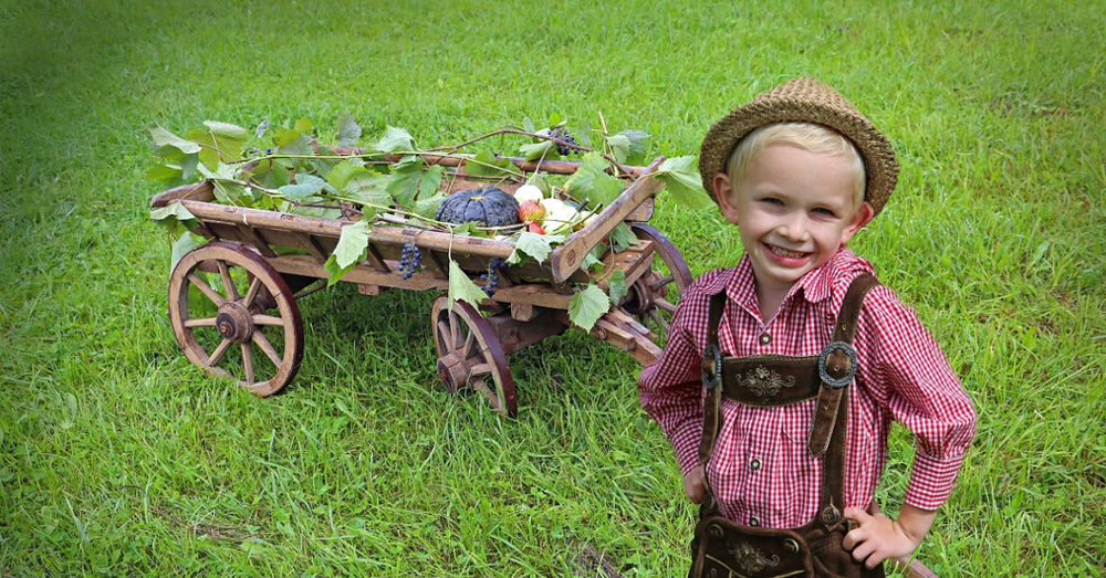 Happy kid with a wagon of vegetables