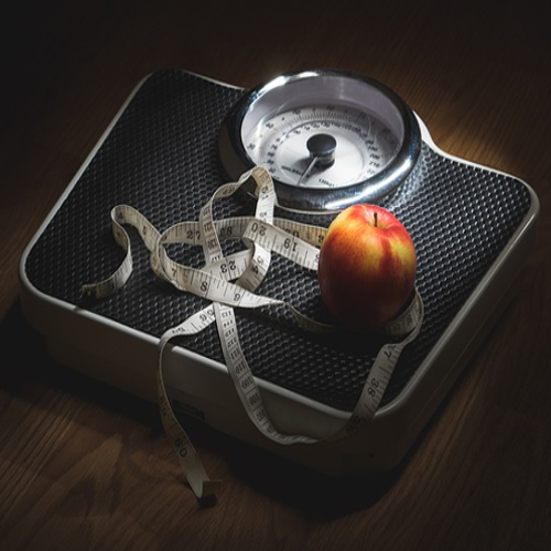 Measuring tape and an apple on a scale