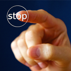 hand pushing a stop button with their finger