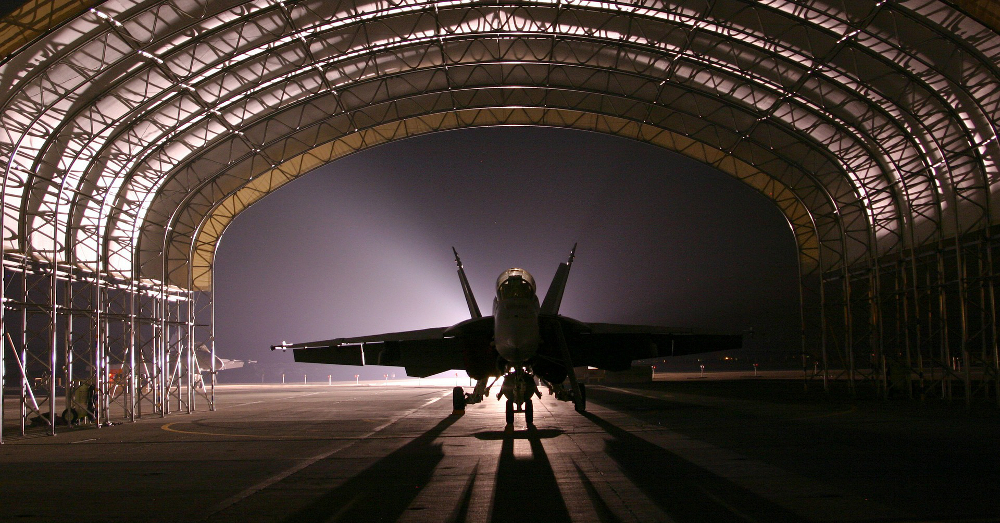 military jet in a dark and shadowy hangar