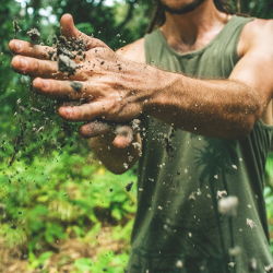 man with handful of soil falling from his hands