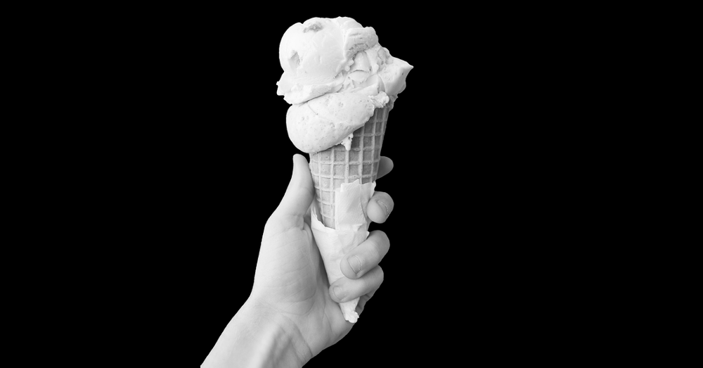 black and white image of a hand holding an ice cream cone