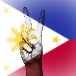 projection of the Philippines flag over a hand with a peace sign