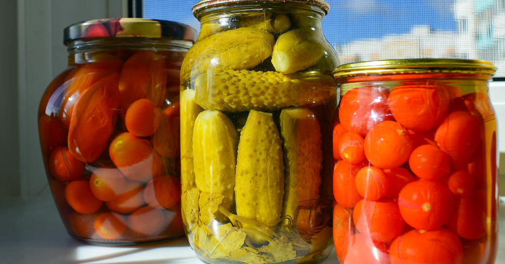 glass jars with canned pickles and tomatoes
