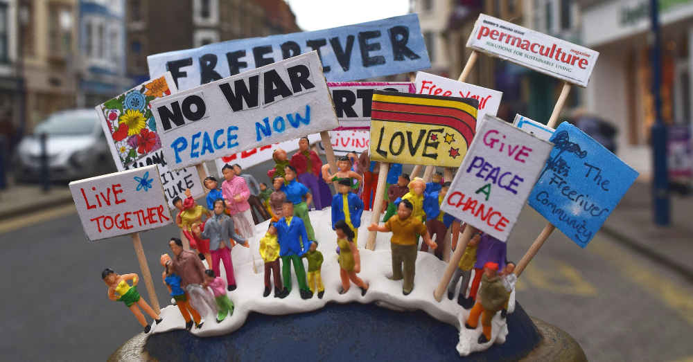 figures and toys arranged with signs protesting war and climate change