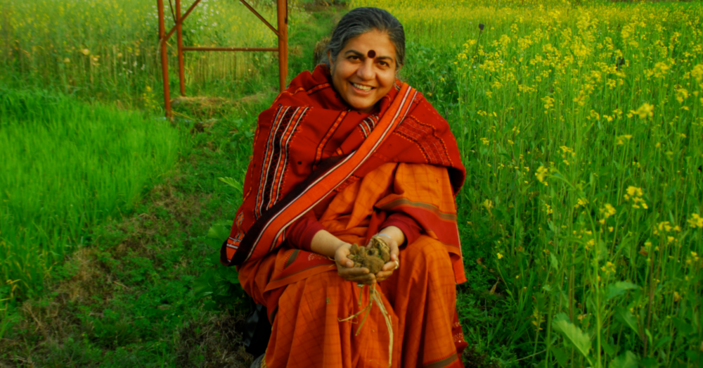 Dr. Vandana Shiva holding crops in the grass