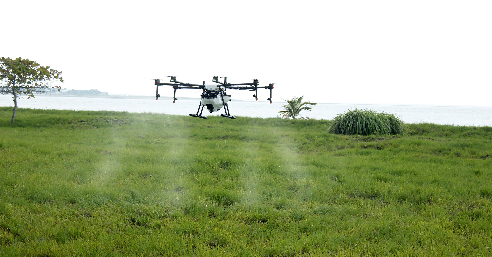 agricultural farm field being sprayed with pesticide or herbicide by a drone
