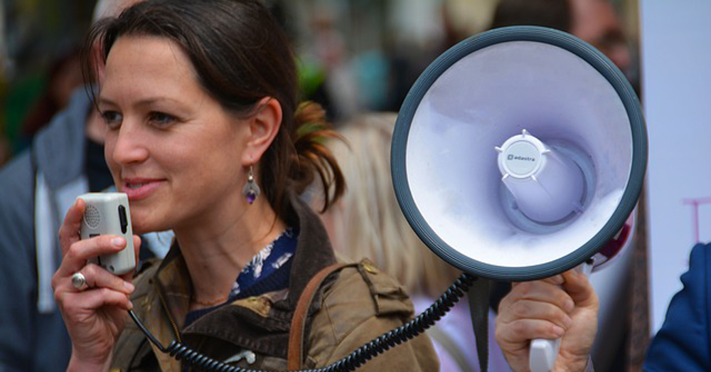 woman at a protest march with a megaphone loud speaker