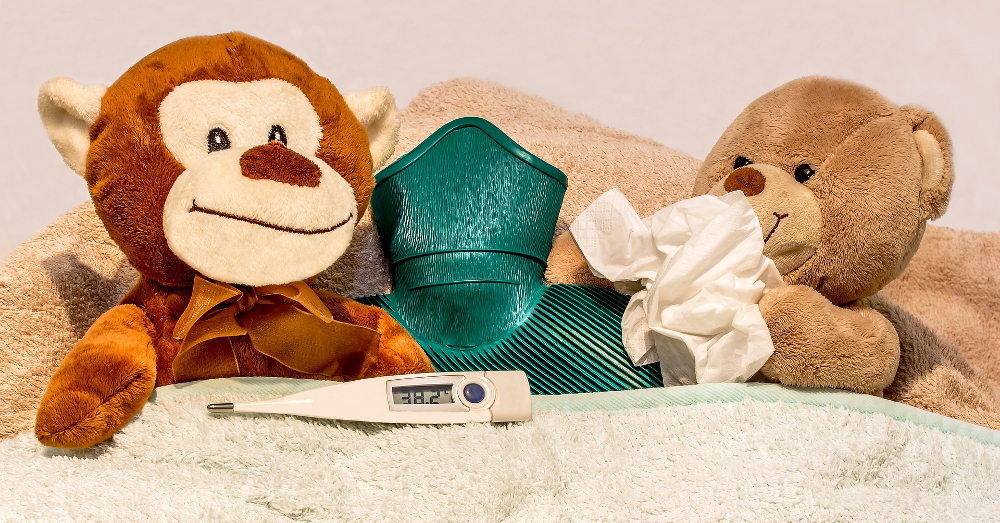 sick stuffed animal toys with tissues a hot water bottle and a thermometer