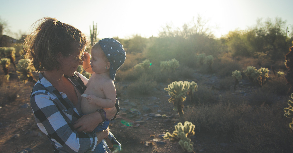 mother and child in the desert landscape at sunset