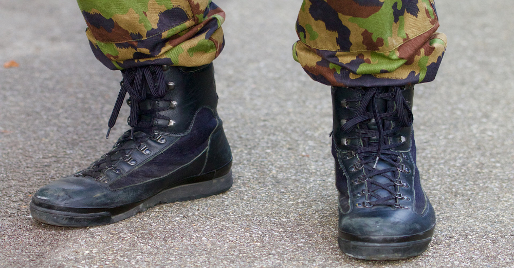 feet of a military soldier wearing black leather combat boots