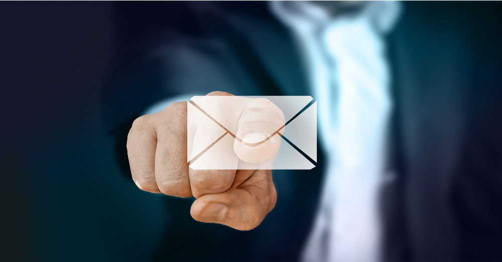 businessman in a suit and tie pointing and touching an email icon