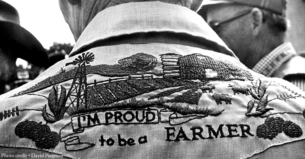 man wearing an embroidered shirt stating I'M PROUD TO BE A FARMER