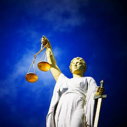 statue of lady justice with eyes closed and set of golden scales