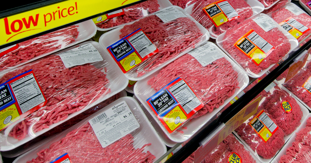 packages of ground beef and meat in a meat cooler at a grocery store