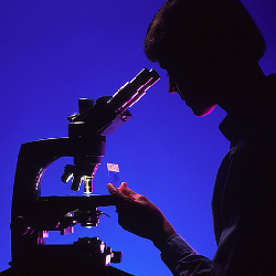 silhouette of a scientist with a microscope and slide