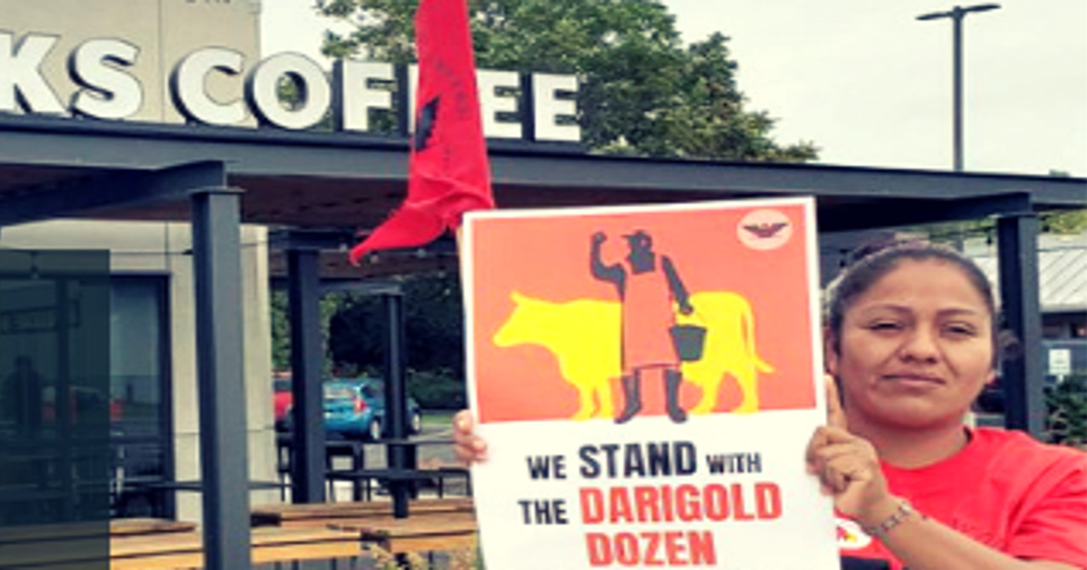 woman standing in protest with a sign outside of a Starbucks coffee shop