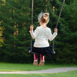 young girl swinging on a playground