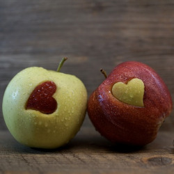 red and green apples with a cut out of a heart in each