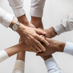 several business people with their hands held together in a huddle