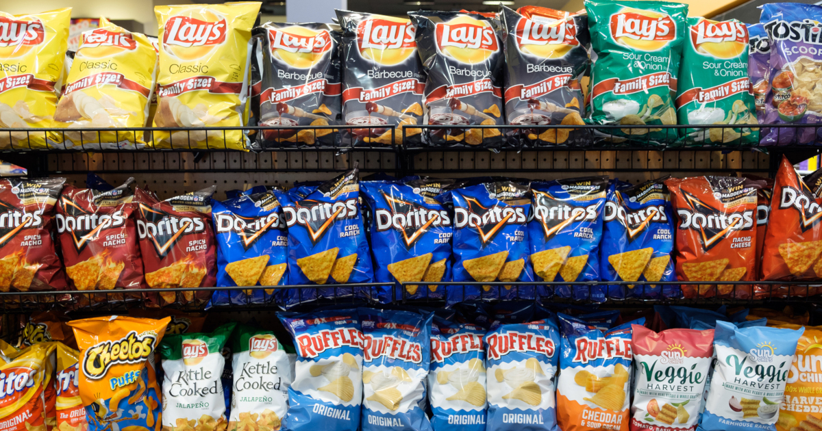 potato chips and other junk food on a store shelf in a supermarket