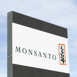 company logo on a sign of Monsanto against a blue cloudy sky