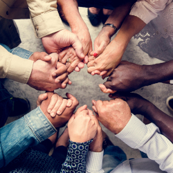 many hands coming together in a circle in teamwork