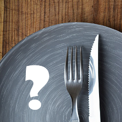 table setting with a knife fork and plate with a white question mark