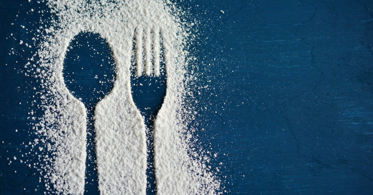 Spoon and fork outlined in white sweetener on a blue background