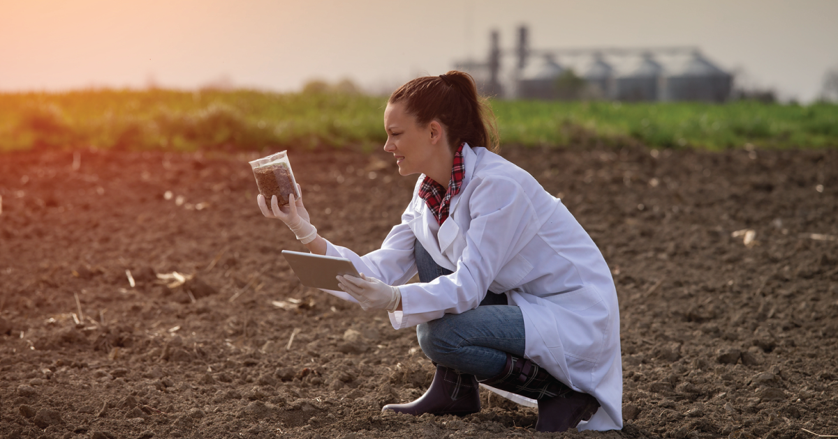 Soil being tested by woman in lab coat.