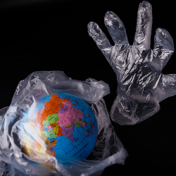 planet earth wrapped in a plastic bag and a plastic glove