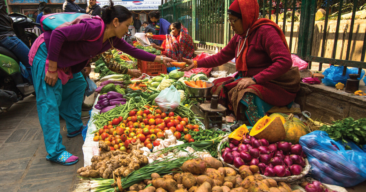 Woman selling produce at a farmers market.