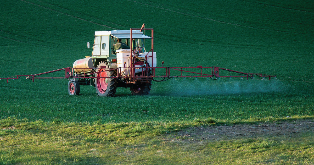 Farmer spraying pesticides with a tractor..