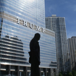 silhouette of a statue in front of Trump tower building