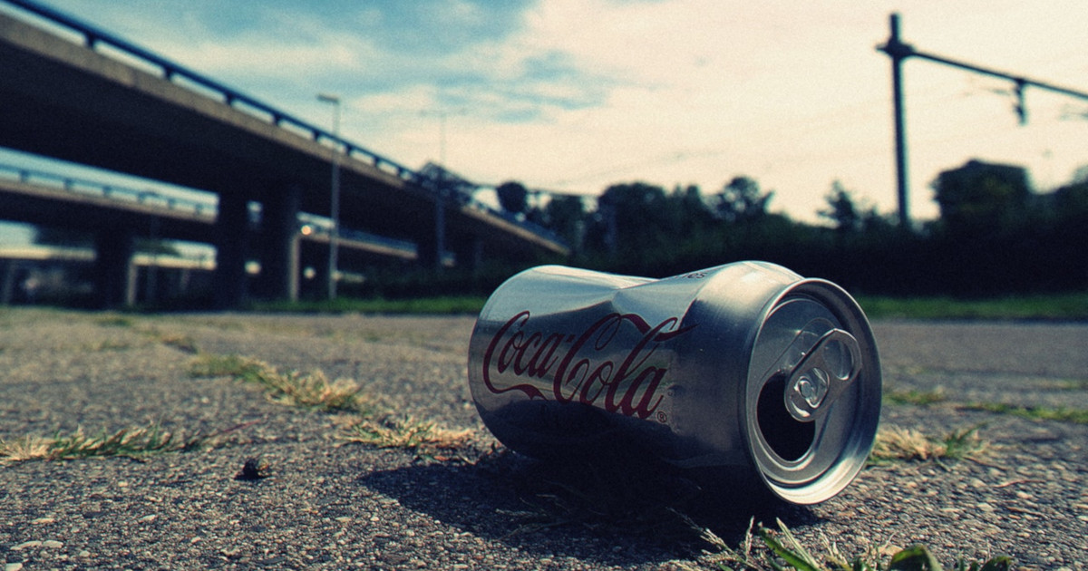 coca cola can litter garbage under a highway bridge
