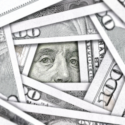 stacks of hundred dollar bills arranged with Benjamin Franklins eyes peering out